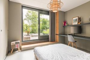 a bedroom with a bed and a large window at Villa Merici in Bergen