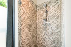 a bathroom with a shower with a tile wall at Villa Merici in Bergen +24 photos