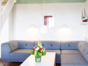 a living room with a blue couch and a table with flowers at 5 person holiday home on a holiday park in Gudhjem in Gudhjem