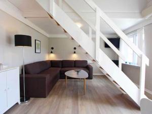 sala de estar con sofá y escalera en 5 person holiday home on a holiday park in Gudhjem, en Gudhjem