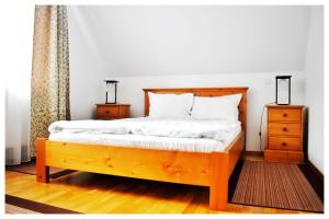 アルバクにあるPensiunea Poienitaのベッドルーム1室(白いシーツが備わる木製ベッド1台付)