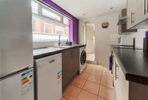 a kitchen with a sink and a dishwasher at Lynam House in Stoke on Trent