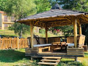 a wooden gazebo with chairs and a table at Au Songe du Valier- Chalets in Seix