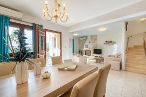 una sala da pranzo e un soggiorno con tavolo e sedie. di Pearls Of Crete - Holiday Residences a Makris Gialos