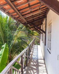 a balcony with a wooden walkway next to a building at Milano Hotel Pousada Canoa Quebrada in Canoa Quebrada