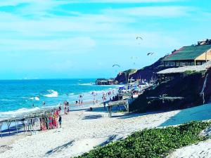 eine Gruppe von Menschen am Strand, die Drachen fliegen in der Unterkunft Milano Hotel Pousada Canoa Quebrada in Canoa Quebrada