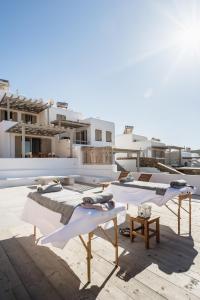 a group of beds sitting on top of a roof at The Mykonist Merchia Beach Villas & Suites in Merchia Beach