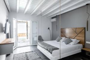 een slaapkamer met een groot bed en een schommel bij The Mykonist Merchia Beach Villas & Suites in Merchia Beach