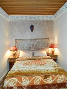 a bedroom with a large bed with two lamps on tables at famille fahym in Fez