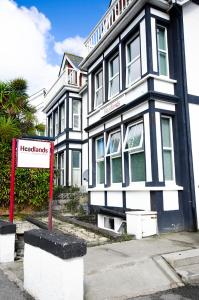 un edificio blanco y negro con un cartel delante en Headlands - Room Only Accommodation en Falmouth