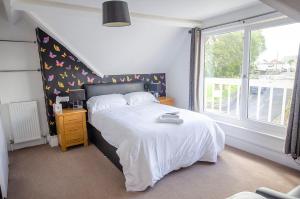 um quarto com uma cama branca e uma janela em Headlands - Room Only Accommodation em Falmouth