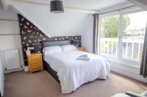 a bedroom with a white bed and a window at Headlands - Room Only Accommodation in Falmouth