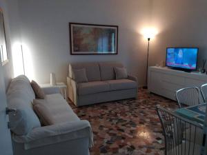 a living room with a couch and a tv at PRIMO PIANO - Bilocale Casa Vacanze Brescia in Brescia