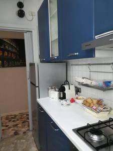 una cucina con armadi blu e piano di lavoro bianco di PRIMO PIANO - Bilocale Casa Vacanze Brescia a Brescia