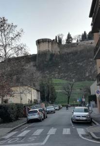 una strada con auto parcheggiate su una collina con un castello di PRIMO PIANO - Bilocale Casa Vacanze Brescia a Brescia