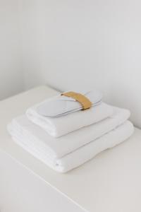 uma pilha de toalhas brancas com um cinto de ouro em Apartamento turístico Legate em Elizondo