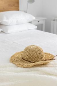 un sombrero de paja sentado en la parte superior de una cama en Apartamento turístico Legate, en Elizondo