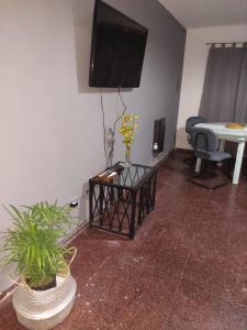 a living room with a flat screen tv and a table at Departamentos Avenida San Martin in Mendoza