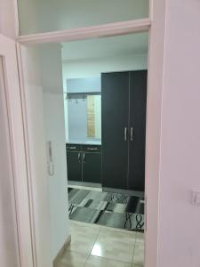 a kitchen with black cabinets and a mirror at Apartman Jaca in Tuzla