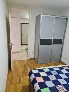 a bedroom with a bed and a sliding door at Apartman Jaca in Tuzla