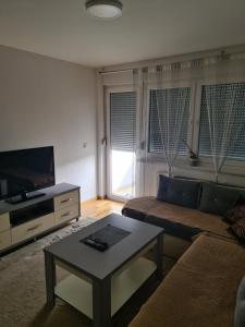 a living room with a couch and a coffee table at Apartman Jaca in Tuzla