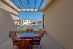 a dining room with a table and chairs and a large window at Brand-New Family House in Tawila El Gouna Lagoon and Pool Access in Hurghada