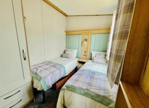 Habitación pequeña con 2 camas. en Prime Location Selsey Chalet Seal Bay, en Selsey