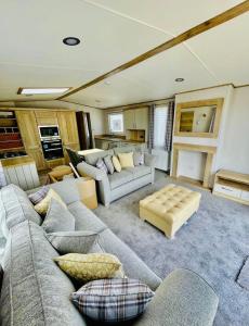 uma grande sala de estar com sofás e uma cozinha em Prime Location Selsey Chalet Seal Bay em Selsey