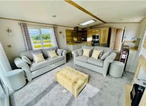 a living room with two couches and a table at Prime Location Selsey Chalet Seal Bay in Selsey