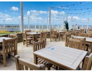 um restaurante com mesas e cadeiras e vista para o oceano em Prime Location Selsey Chalet Seal Bay em Selsey