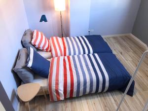 Una cama y un sofá con una manta. en Appartement lumineux avec grande terrasse en Clermont-Ferrand