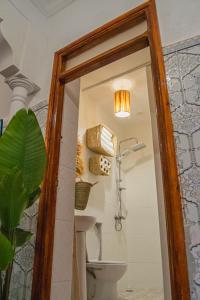 Riad Fz Marrakech في مراكش: مرآة في حمام مع مرحاض وضوء