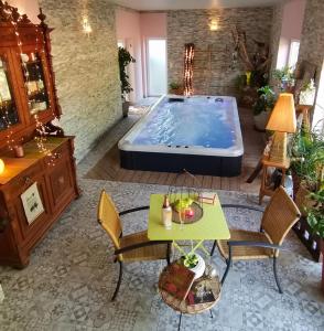 een groot zwembad in een kamer met een tafel en stoelen bij Fairytale Memories SPAS Privatifs in Varsberg