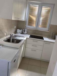 a white kitchen with a sink and a stove at Apartment in Klek 6258 in Klek