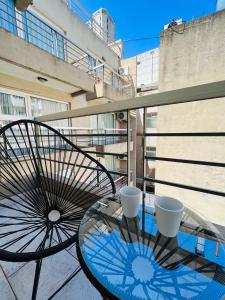 una mesa de cristal con una sombrilla en el balcón en Departamento Monoambiente Puerto Madero y Retiro en Buenos Aires