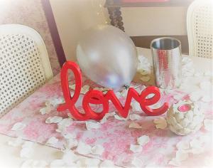 een ballon en het woord liefde op een tafel bij Fairytale Memories SPAS Privatifs in Varsberg