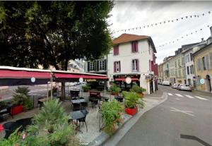 塔布的住宿－T2 de charme, centre ville historique de Tarbes，一条设有桌椅的街道和一座建筑