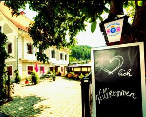 a sign with a heart on it next to a building at Gasthof Altes Hammerherrenhaus in Übelbach