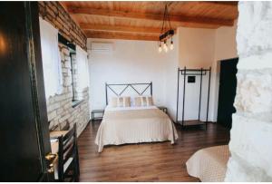 een slaapkamer met een bed in het midden van een kamer bij Bujtina Maria in Gjirokastër