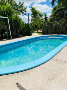 una gran piscina azul en un patio en Pousada Neide, en São Gabriel
