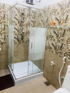 a shower with a glass enclosure in a bathroom at Udara Guest - Yala Safari in Yala