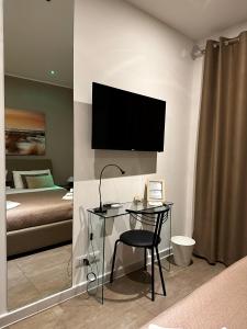 a bedroom with a desk and a television on a wall at Marilù in Palermo