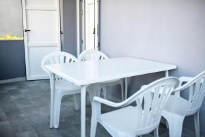 una mesa blanca y sillas blancas en una habitación en Pinarella-Cervia INTERA CASA PRIVATA A 100M DAL MARE, en Cervia