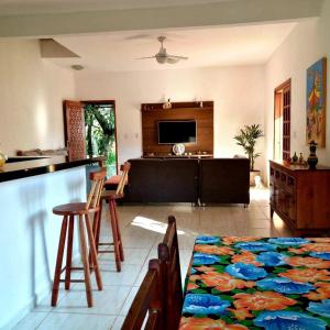a living room with a couch and a table with chairs at Casa Kauai Boiçucanga in São Sebastião
