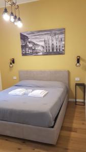 1 cama en un dormitorio con una pintura en la pared en MagnoliaApartments - 18B Visconti Duomo en Milán