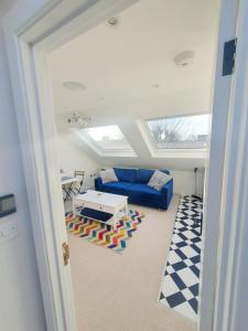 - un salon avec un canapé bleu et une table dans l'établissement Jacuzzi Suite, à Londres
