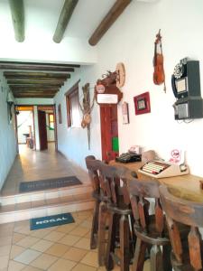 Habitación con mesa de madera con sillas y violín. en Hotel El Peregrino De La Villa, en Villa de Leyva