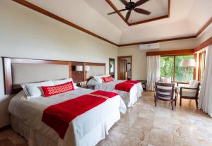 a bedroom with two beds and a table and chairs at Bolontiku Boutique Hotel & Spa in Flores