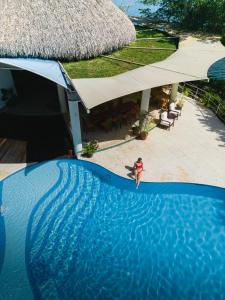 une femme en bikini debout dans une piscine dans l'établissement Bolontiku Boutique Hotel & Spa, à Flores