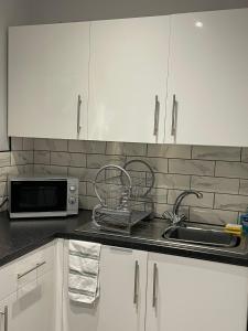 a kitchen counter with a sink and a microwave at 264 The Road End in Liverpool